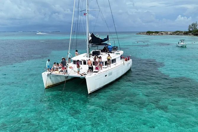 Catamaran cruising past an island on a Nassau Bahamas snorkeling three-stop tour with Pig Beach and sea turtles in Nassau
